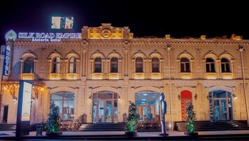 The Silk Road Empire historic hotel with ornate architecture, large arched windows, and a prominent sign.