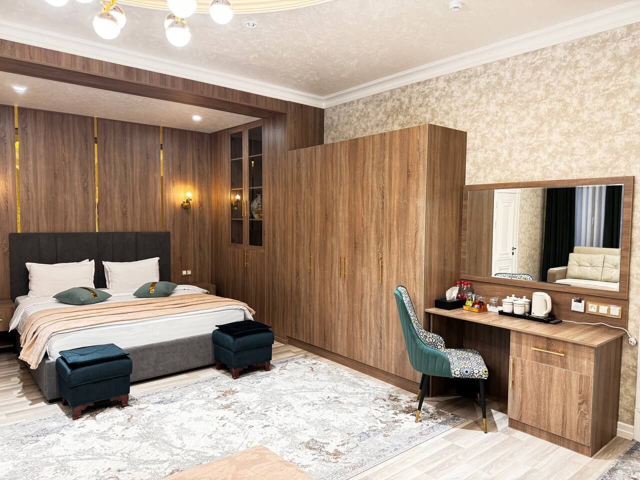 A bedroom with a large bed, a desk, and a wardrobe.