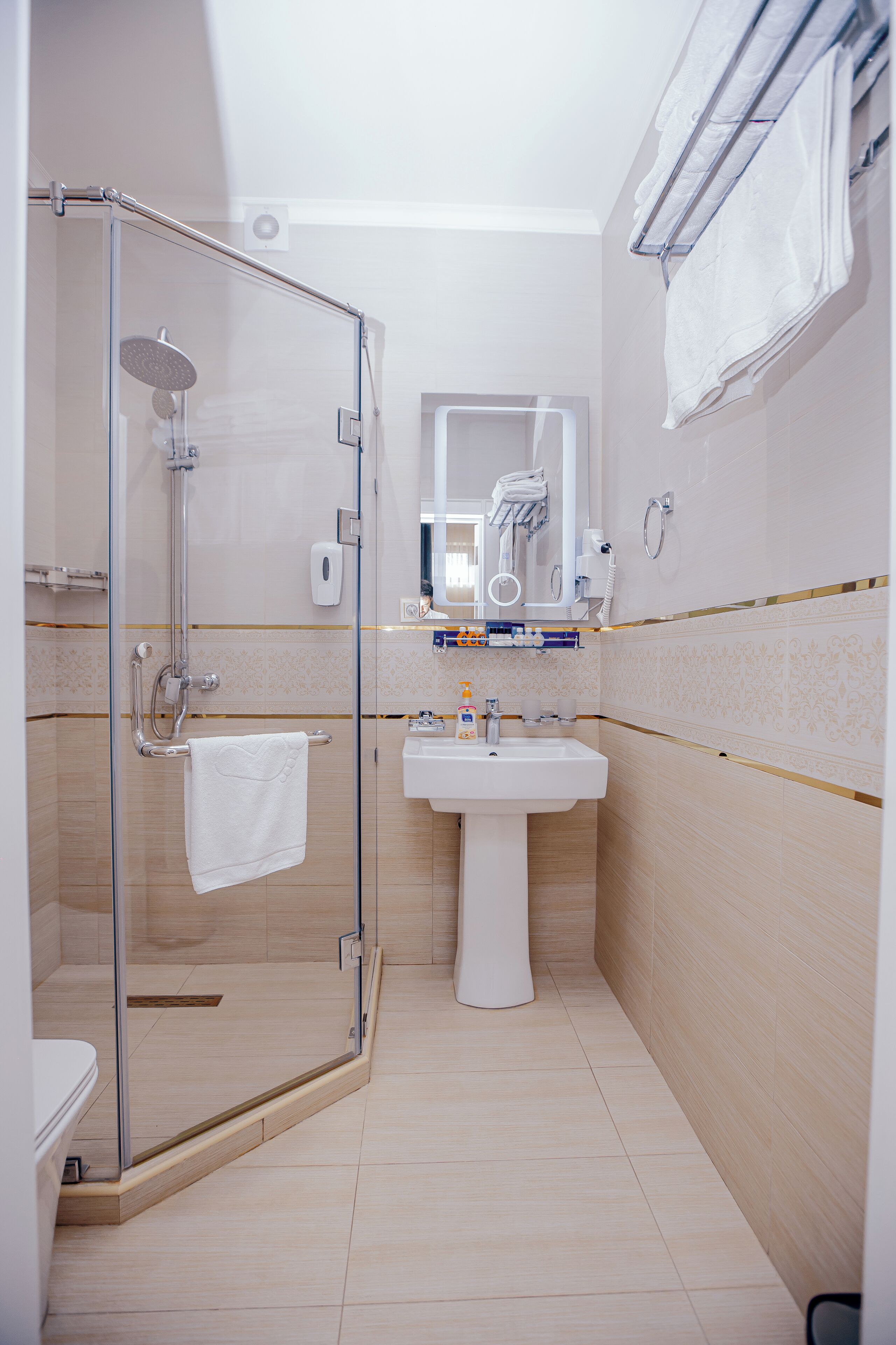 Un baño moderno con ducha acristalada, lavabo y espejo.