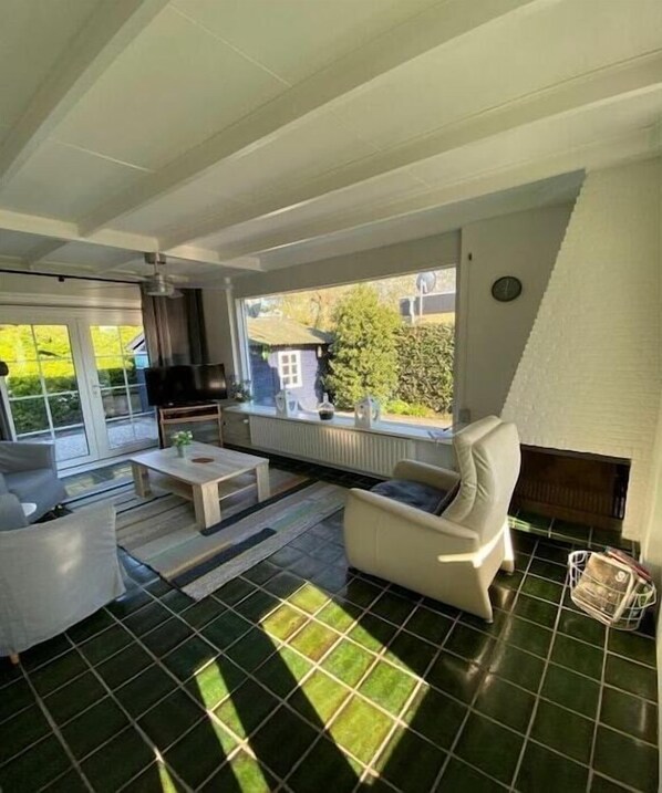 Relax in this stylish living room with a fireplace, garden views, and comfortable seating.