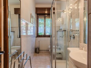 A modern bathroom with a glass shower enclosure, a toilet, and a sink. - Mariarosa by Interhome (Dongo)