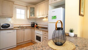 A kitchen with light wood cabinets, a white refrigerator, a microwave, a stove, and a sink. - Bel-Air by Interhome (Calpe/Calp)