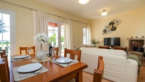 A dining area with a wooden table set for two, a sofa, and a TV in the living area. - Bel-Air by Interhome (Calpe/Calp)