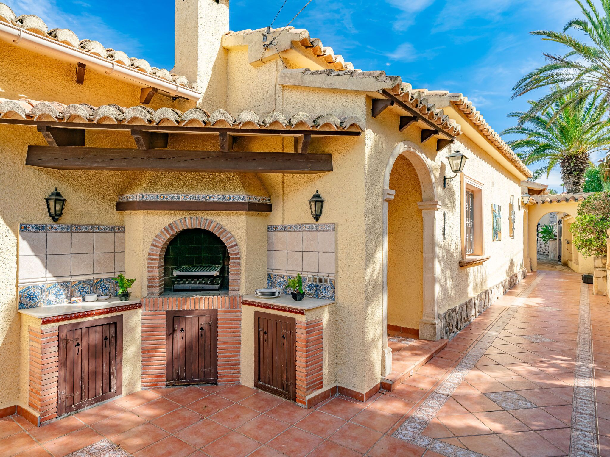 A traditional Mediterranean-style building with a brick oven, tiled walls, and a tiled patio area.