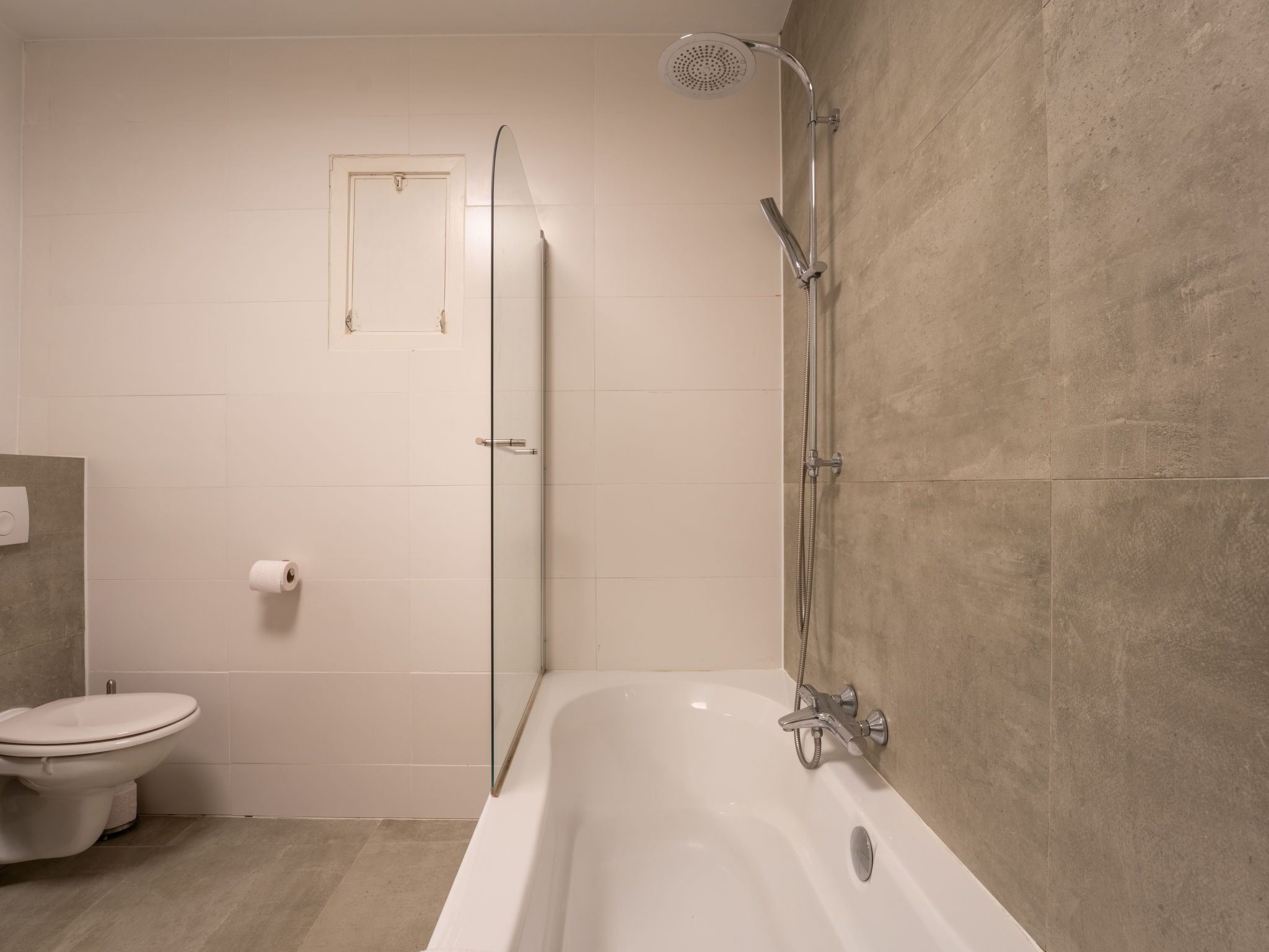 Ein modernes Badezimmer mit Badewanne, Dusche und Toilette.