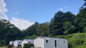 Een rij mobiele woningen met een picknicktafel en een trap naar de ingang.