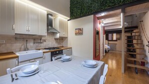 A modern kitchen with white cabinets, a gas stove, and a dining area with a table set for two.