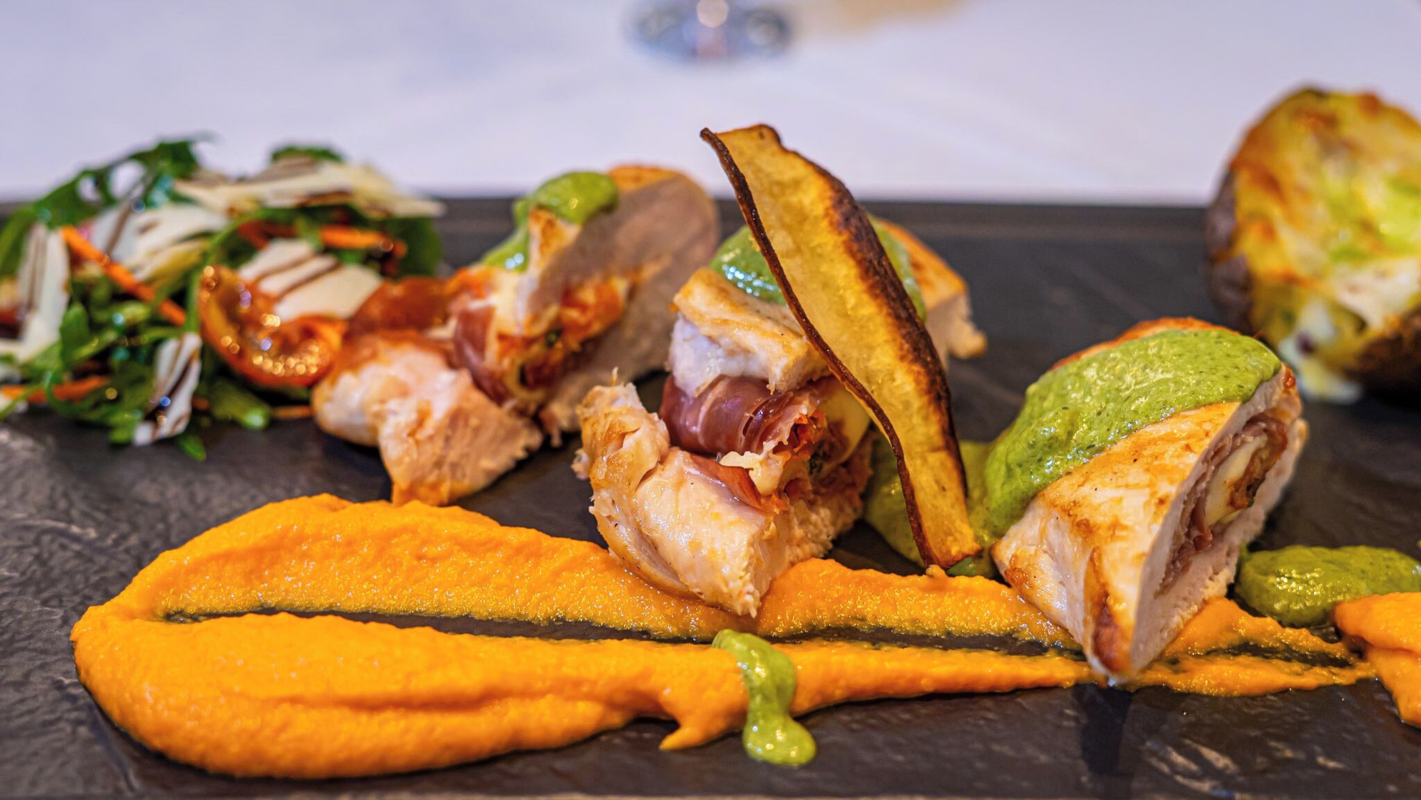 Variedad de platos, incluyendo una ensalada, patatas asadas y un plato principal con carne y verduras.