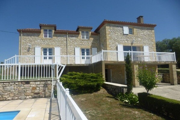A two-story stone house with a balcony, a swimming pool, and a well-maintained garden. - House in Monségur with Panoramic Views (Monségur)