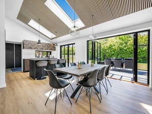 A modern kitchen with a dining area, large windows, and a view of greenery. - "Tähti" - 425m from the sea by Interhome (Føllenslev)