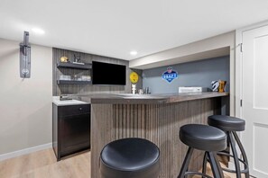 Een moderne keuken met een bar, een klok en een bord waarop een NFL Draft evenement wordt aangekondigd.