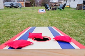 A backyard with a lawn, a wooden deck, and a house in the background.