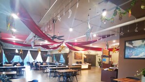 A spacious restaurant with multiple dining areas, ceiling fans, and hanging decorations. - Sam's Vacation @ The Straits Suite Residence formerly Ramada Suite by Wyndham (Johor Bahru)