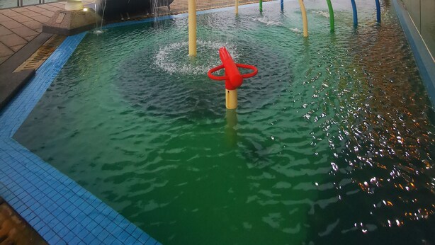 A swimming pool with a water fountain, a red mushroom-shaped structure, and a green and blue arch. - Sam's Vacation @ The Straits Suite Residence formerly Ramada Suite by Wyndham (Johor Bahru)
