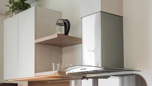 A modern kitchen with a central island, a built-in oven, and a stainless steel range hood. - HN ETH Vinhomes D'capitale Resident (Hanoi)