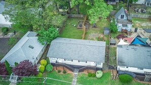 A residential area with houses, a fenced yard, and a small deck. - Boho Westside Retreat | Fire Pit + Walk to Eats (Atlanta)
