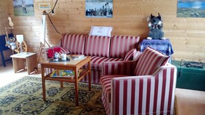 Una sala de estar acogedora con un sofá a rayas, una mesita de madera y un jarrón decorativo.