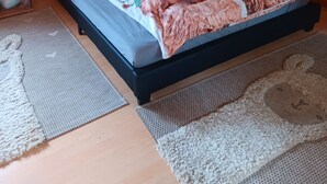Una habitación acogedora de madera con una cama, una lámpara de pared y un cuadro con una llama.