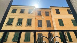Un edificio a più piani con persiane verdi e cielo sereno.