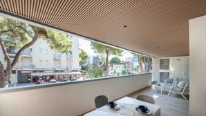 A modern dining area with a large window overlooking a street. - Elegant downtown hideaway (Lignano Sabbiadoro)