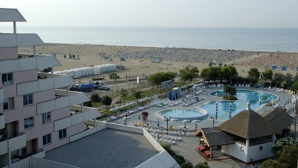 Un complexe hôtelier doté d’une grande piscine, d’une plage et de plusieurs bâtiments.
