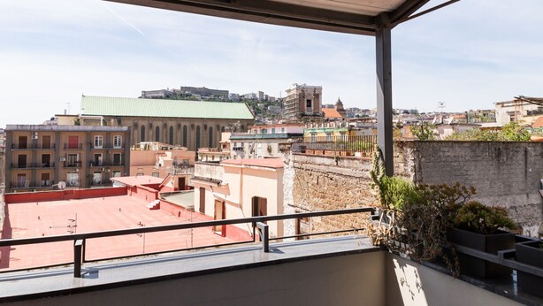 A balcony with a view of a cityscape, including buildings and a distant castle. - Santa Chiara in the city centre (Napoli)