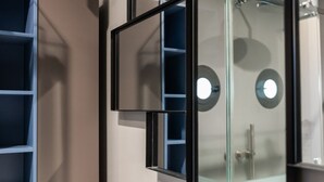 A bathroom with a glass shower enclosure, a white sink, and a mirror. - Santa Chiara in the city centre (Napoli)