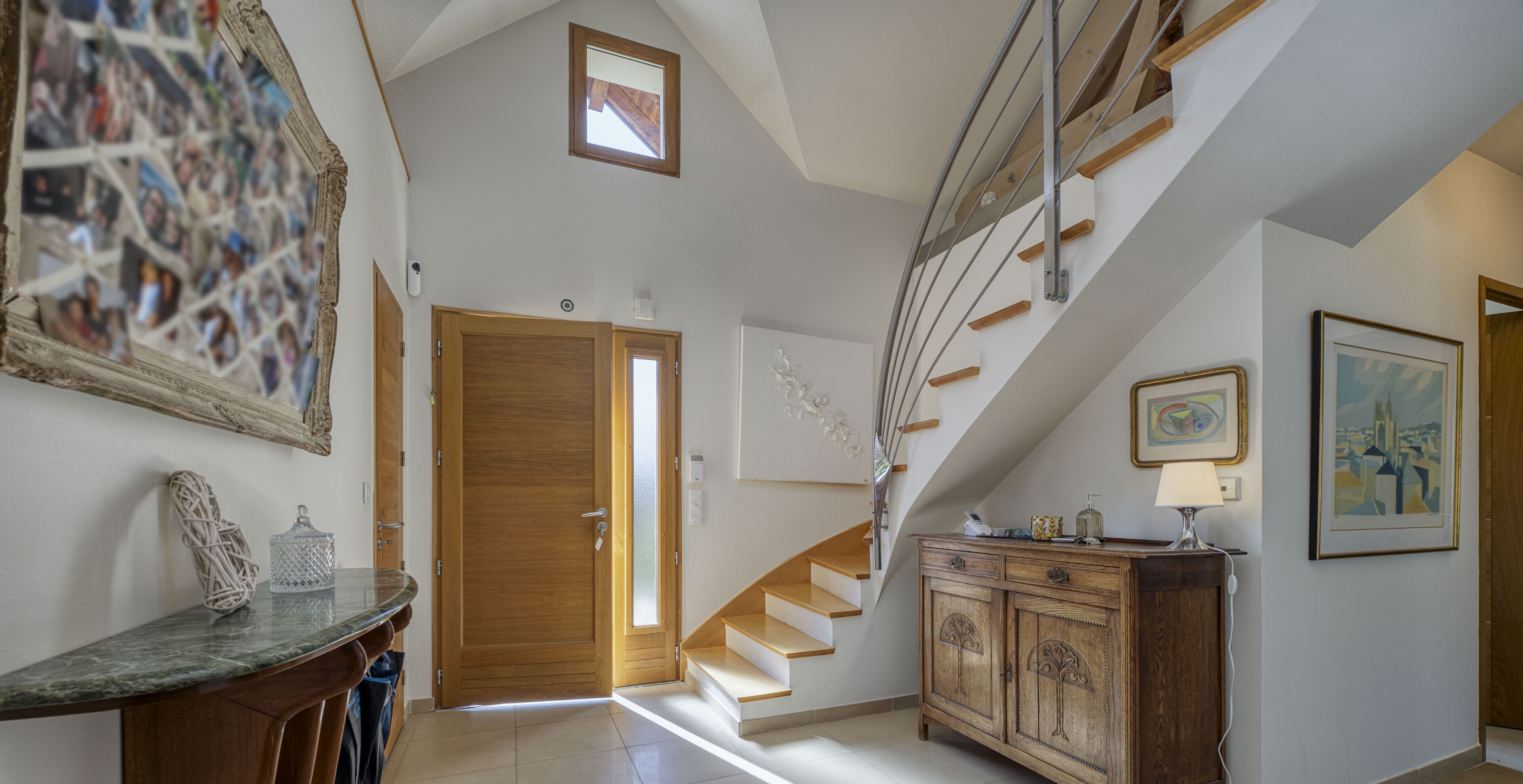 Ein geräumiger Flur mit einer Holztreppe, einer Holztür und einem Schrank mit Schubladen.