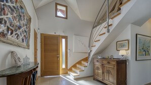Ein geräumiger Flur mit einer Holztreppe, einer Holztür und einem Schrank mit Schubladen.