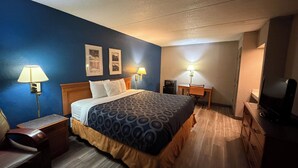 A hotel room with a bed, desk, chair, TV, and two wall-mounted lamps. - Garden inn and suites san antonio l 35 (San Antonio)