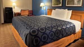A hotel room with a bed, a desk, a chair, a microwave, and two wall-mounted lamps. - Garden inn and suites san antonio l 35 (San Antonio)
