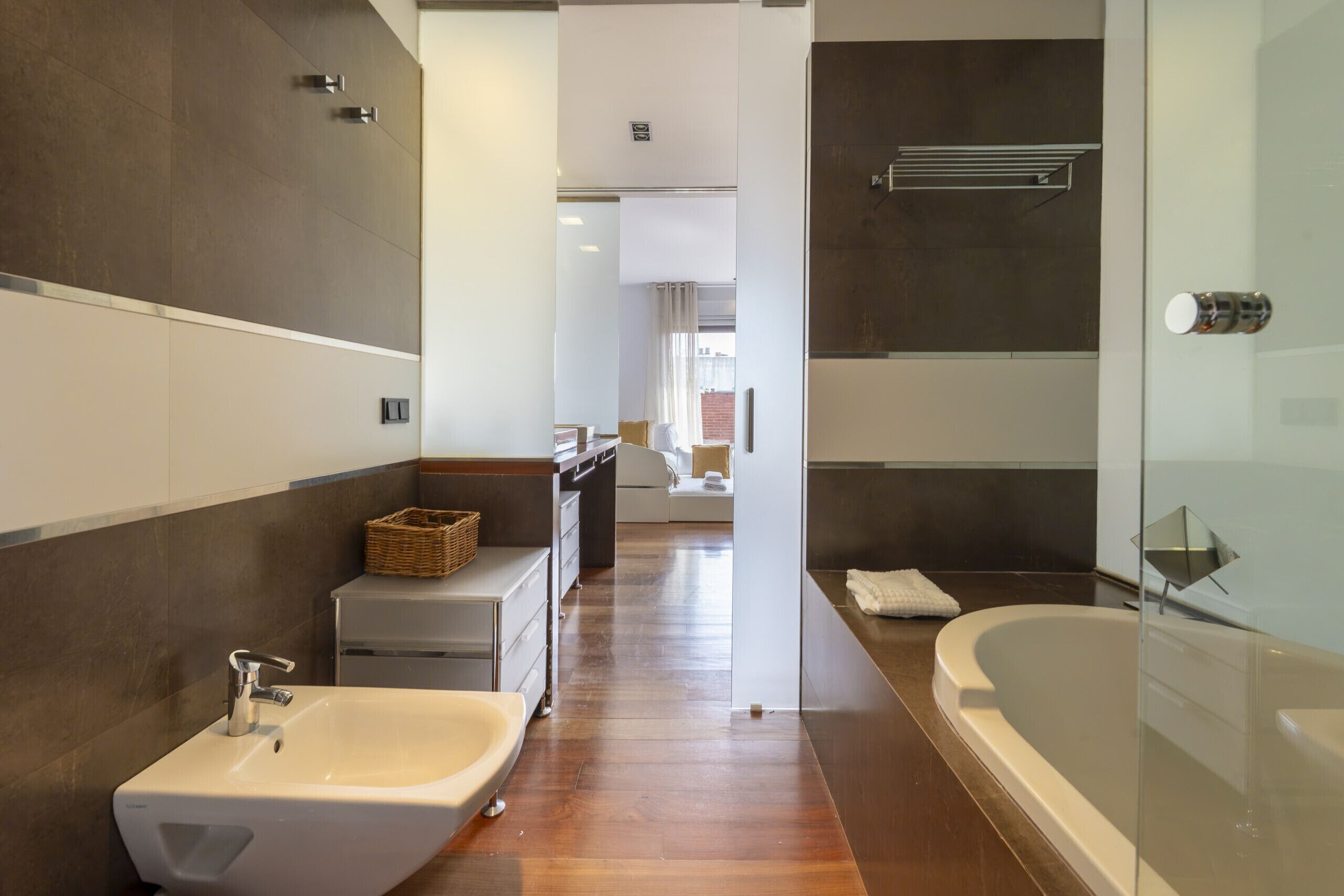 A modern bathroom with a large bathtub, a sink, and a shower area.