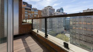 A balcony with a view of surrounding buildings, a glass door, and a small outdoor seating area. - 3 Bedroom Duplex - Spacious, Bright near the Paseo de la Castellana (Madrid)