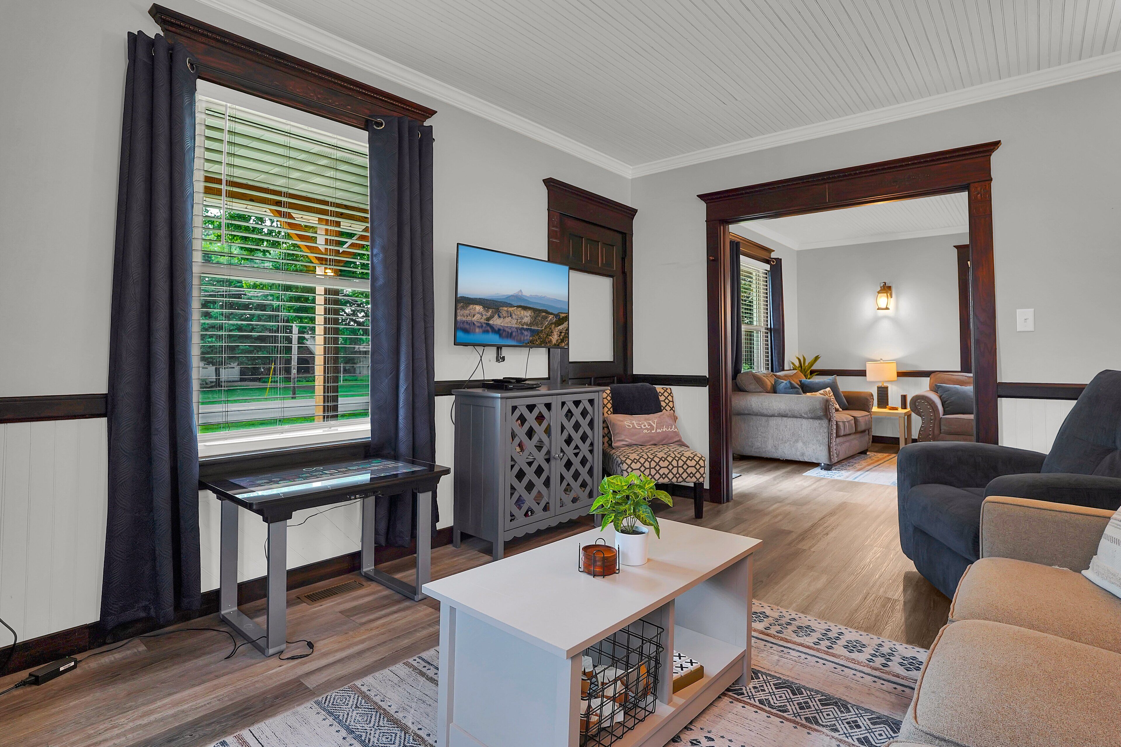 A modern living room with a flat-screen TV, a coffee table, and a sofa.