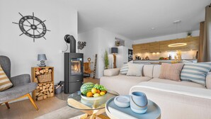 En moderne stue med en sofa, et glasbord og en pejs.