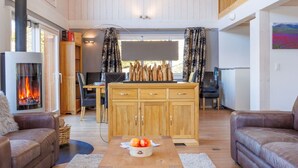 Un salon chaleureux avec une cheminée, des meubles en bois et un coin repas.