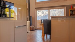 Une cuisine moderne dotée d’une grande fenêtre, d’un plancher en bois et d’un coin repas avec une table et des chaises.