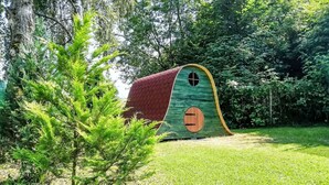 A small, green, house-shaped structure with a red roof and a circular window, surrounded by lush greenery. - Wonderful private villa for 11 people with WIFI, terrace and pets allowed (Ceský Krumlov)