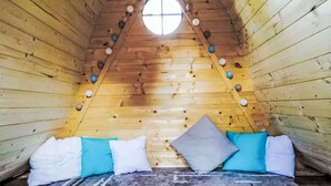 A cozy wooden cabin with a sloped ceiling, a central window, and a bed with pillows. - Wonderful private villa for 11 people with WIFI, terrace and pets allowed (Ceský Krumlov)