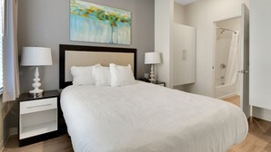 A neatly arranged bedroom with a large bed, two bedside tables with lamps, a wardrobe, and a shower area. - Simplicity At the Rim 1119 I Spacious 1 Bed 1 Bth (San Antonio)