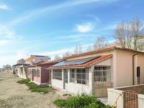 A row of residential buildings with solar panels on the roofs, a sandy ground, and some greenery. - Wonderful private villa for 6 guests with A/C, WIFI, balcony and pets allowed (Follonica)