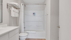 Une salle de bain moderne équipée d’une douche, de toilettes et d’un meuble-lavabo.