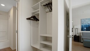 A walk-in closet with open doors, revealing shelves and hanging space.