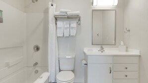 A modern bathroom with a shower, toilet, and sink.