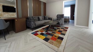 A modern living room with a grey sofa, a coffee table, and a colorful rug. - Ganzo Boutique Hotel (Bucharest)