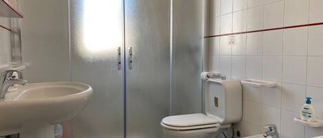 A bathroom with a toilet, bidet, and two sinks.