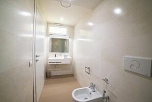 Een douche, een haardroger, een bidet, handdoeken