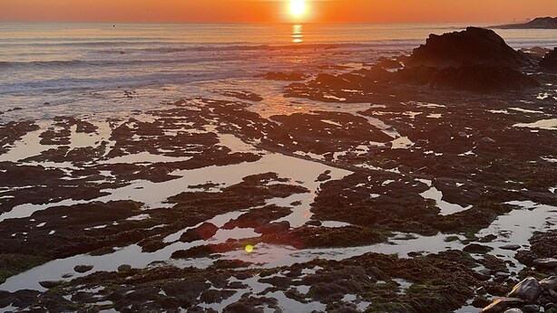 A rocky shoreline at sunset with the sun low on the horizon. - Comfortable mobile home near the Atlantic (Talmont-Saint-Hilaire)