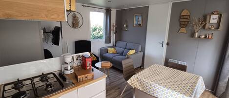 A compact living space with a kitchenette, a dining area, and a sofa.