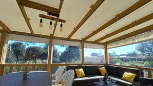 A covered outdoor seating area with a table, chairs, and a sofa. - Comfortable mobile home near the Atlantic (Talmont-Saint-Hilaire)